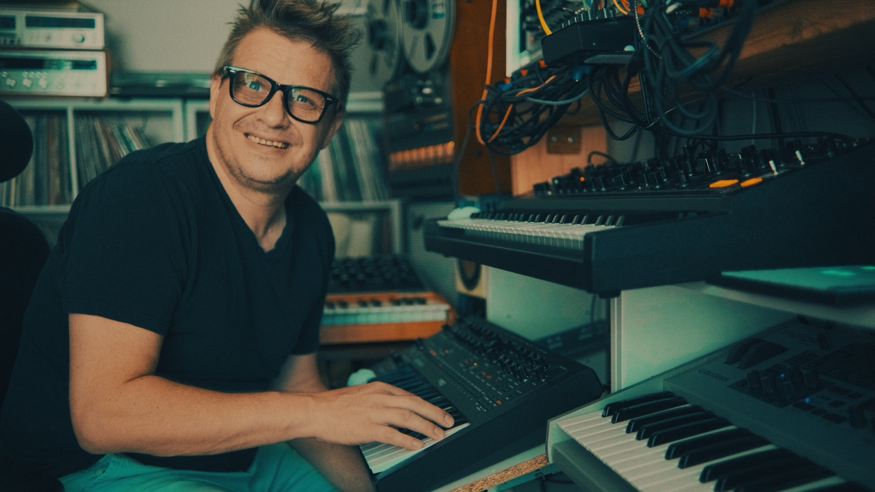 Caught In Joy at a synthesizer in his studio